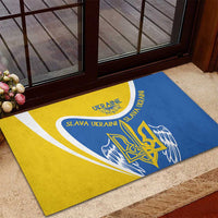 Blue and yellow rubber doormat with winged trident emblem and “Slava Ukraini”
