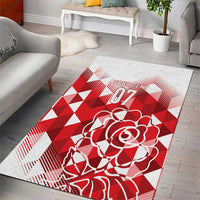 Rectangular area rug featuring a red rose graphic on a red-and-white geometric design