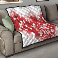 White and red quilt throw on a couch with diamond pattern and rose “07” graphic