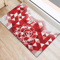 Red and white corner-view rubber doormat with rose graphic on triangle pattern