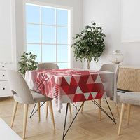 Red and white geometric tablecloth draped over a dining table