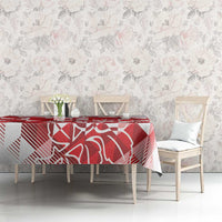 Red and white geometric tablecloth with rose-style artwork on a dining table