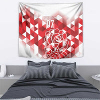 Red and white tapestry featuring geometric blocks and outlined rose design, displayed on wall