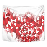 Close-up red and white tapestry showing geometric pattern and outlined rose graphic