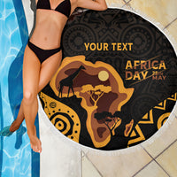 Round beach blanket with white fringe, black-and-gold Africa Day graphic by pool