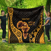 Personalized quilt spread on grass in black and gold with Africa silhouette and 'AFRICA DAY'.