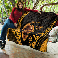Personalized quilt held on patio, black and gold pattern with Africa silhouette and 'YOUR TEXT'.