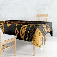 Black tablecloth with bold gold geometric and wave patterns, draped over dining table