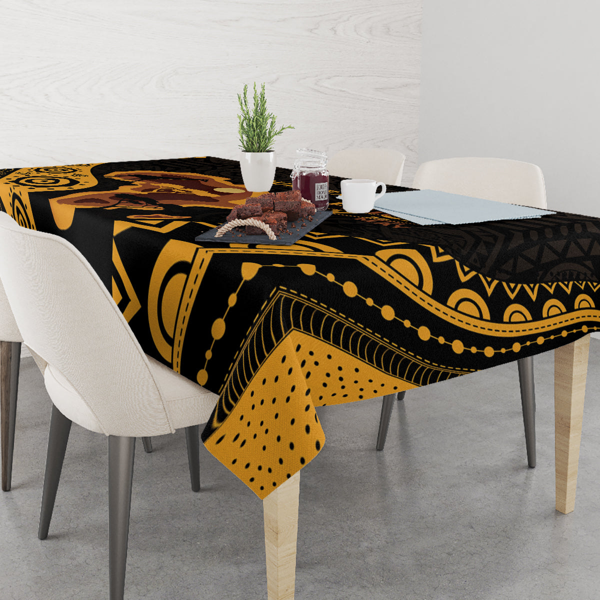 Black tablecloth with gold tribal patterns and dotted accents, styled on dining table