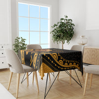 Black tablecloth with gold tribal design and scalloped edge, set on dining table