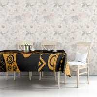Black tablecloth with gold Africa-inspired motifs, visible corner detail on dining table