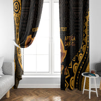 Black and gold Africa Day curtain panels framing a window with printed text motifs
