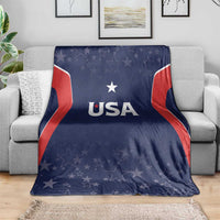 Navy USA-themed blanket with 'USA' logo and starry design, laid over gray sofa