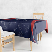 Blue tablecloth with star pattern and red border draped over dining table corners
