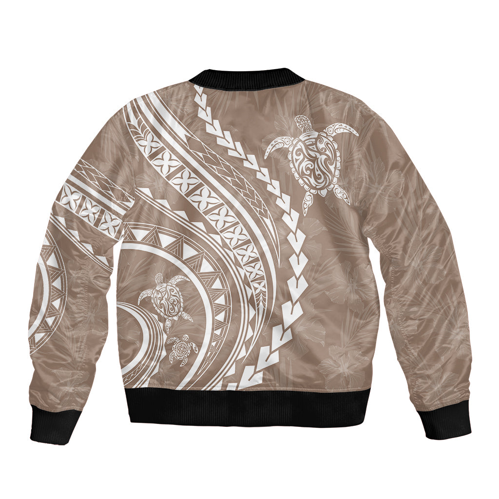 Beige bomber jacket with black ribbed hem and collar, back tribal patterns and turtle graphic