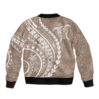 Beige bomber jacket with black ribbed hem and collar, back tribal patterns and turtle graphic