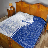 White and blue personalized quilt on a bed, showing crown and anchor designs with text area