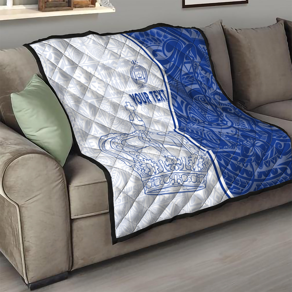 White and blue personalized quilt draped on a sofa, featuring crown and anchor designs