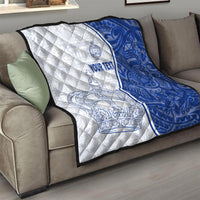 White and blue personalized quilt draped on a sofa, featuring crown and anchor designs