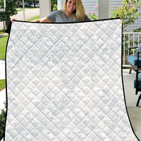 White quilt with diamond stitching and black fabric border, flat on display.
