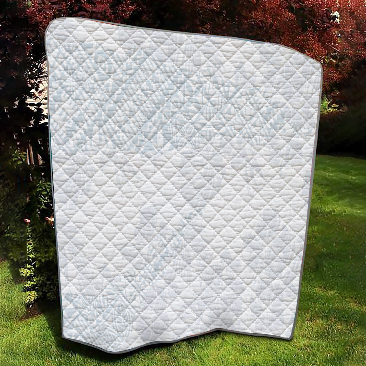 White quilt blanket with diamond quilting and black border corner curve.