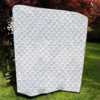 White quilt blanket with diamond quilting and black border corner curve.