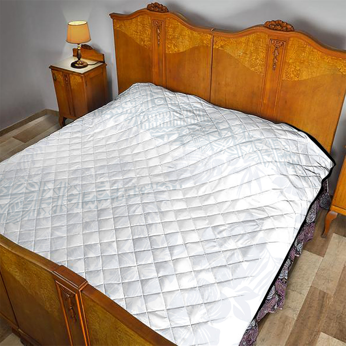 White diamond-quilted quilt covering a bed, with dark edge trim.