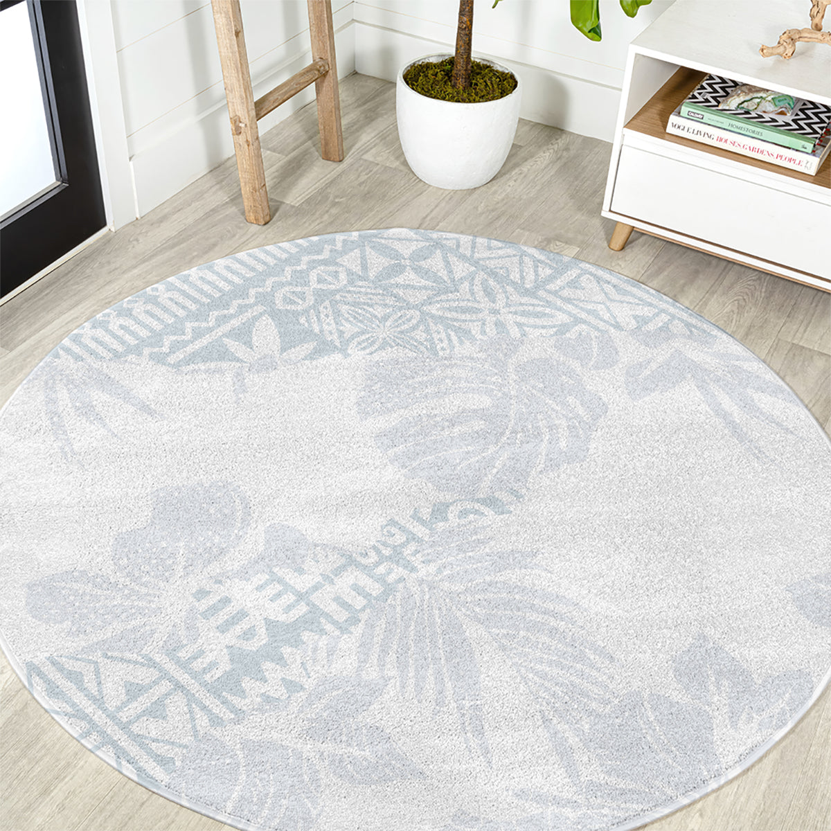 Round light blue rug with hibiscus floral pattern and stitched circular border