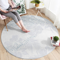 Round light blue rug with hibiscus-style floral pattern and textured woven surface