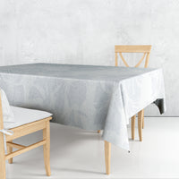 Light-blue floral tablecloth draped over a dining table with an overhang edge.