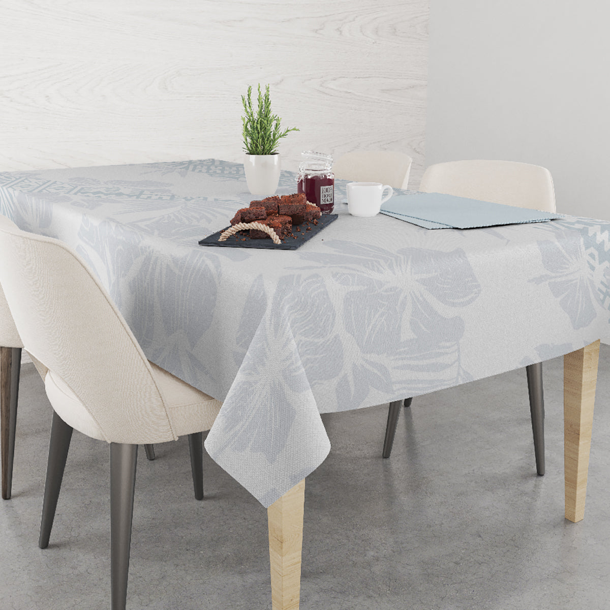 Light-blue floral tablecloth on a round dining table with chairs and serving items.