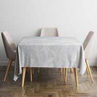 Light-blue floral tablecloth covering a square table with four upholstered chairs.