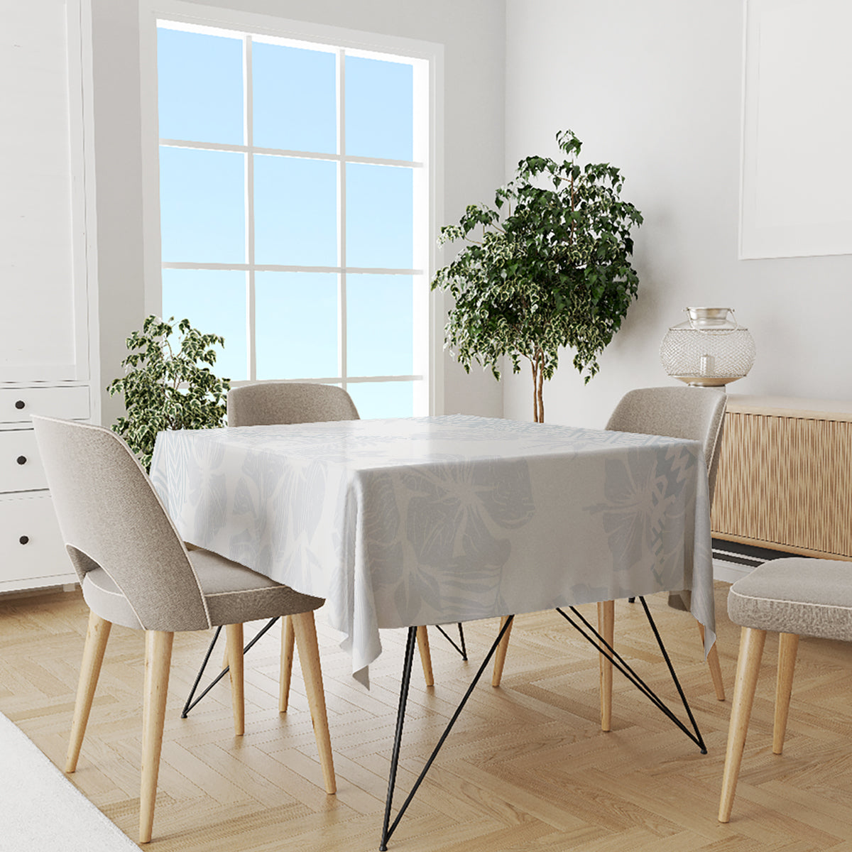 Light-blue floral tablecloth on a dining table with mixed beige and gray chairs.