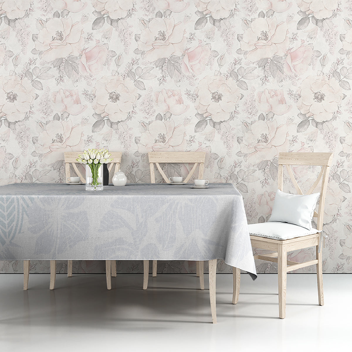 Light-blue floral tablecloth on a dining table with chairs against a floral wall.