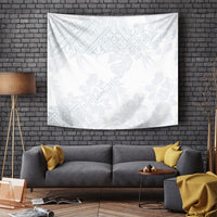 White tapestry with light blue hibiscus and leaf pattern, draped on a living-room wall.