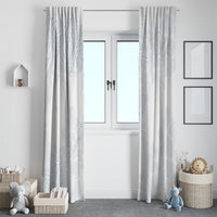 White window curtain panels with light blue botanical print, symmetrical framing over doorway