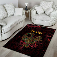 Red and black Sankofa area rug with yellow-green bird motif and Adinkra symbol border