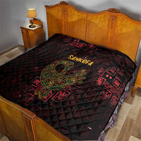 Red and black Sankofa bird symbol quilt on a bed, quilted diamond texture and Adinkra motifs