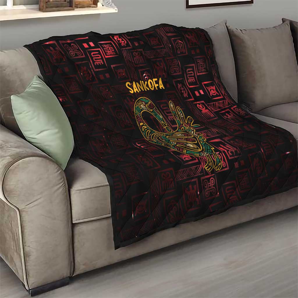 Red and black Sankofa bird symbol quilt on a sofa with quilted diamonds and Adinkra designs