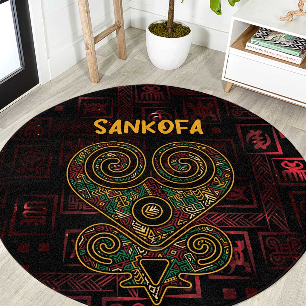 Round red area rug with Sankofa heart symbol in green and gold on black