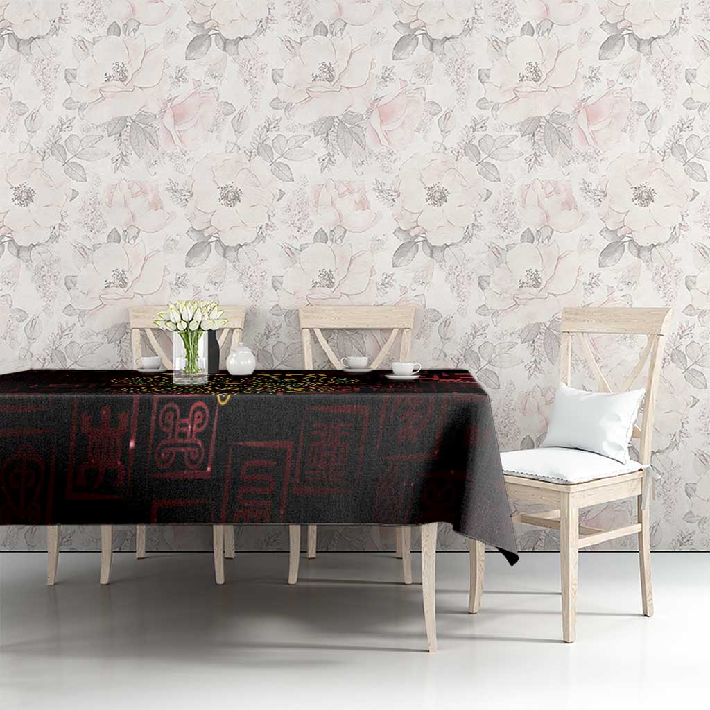 Dark red tablecloth with Sankofa heart and Adinkra symbol pattern on dining table