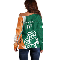 Green off-shoulder rugby sweater back with orange sleeves, 'YOUR TEXT 07' shamrock football