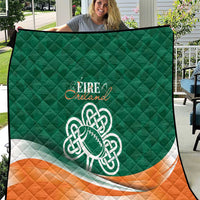 Green quilt with orange-and-white stripe, Celtic knot emblem, and stitched diamond pattern.