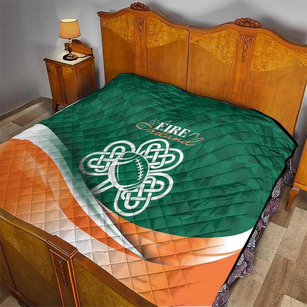 Green bed quilt with Celtic knot emblem, orange bottom panel, and white curved band.
