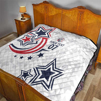 White quilt covering a bed with blue and red star and patriotic emblem print