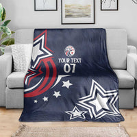 Blue custom rugby blanket on a gray couch with eagle logo, stars, and “YOUR TEXT 07”