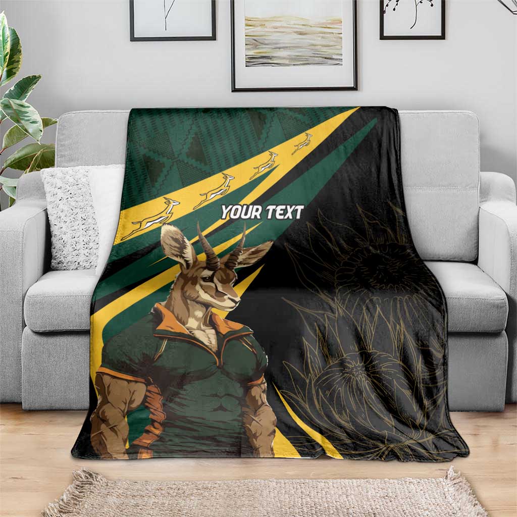Personalized springbok mascot blanket draped on sofa with “YOUR TEXT” and diagonal stripes