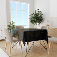 Black tablecloth with gold and green scenic graphic on a dining table