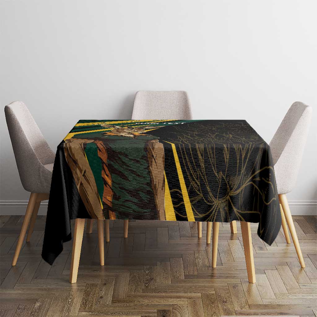 Black tablecloth on dining table with gold-striped section and leaf artwork