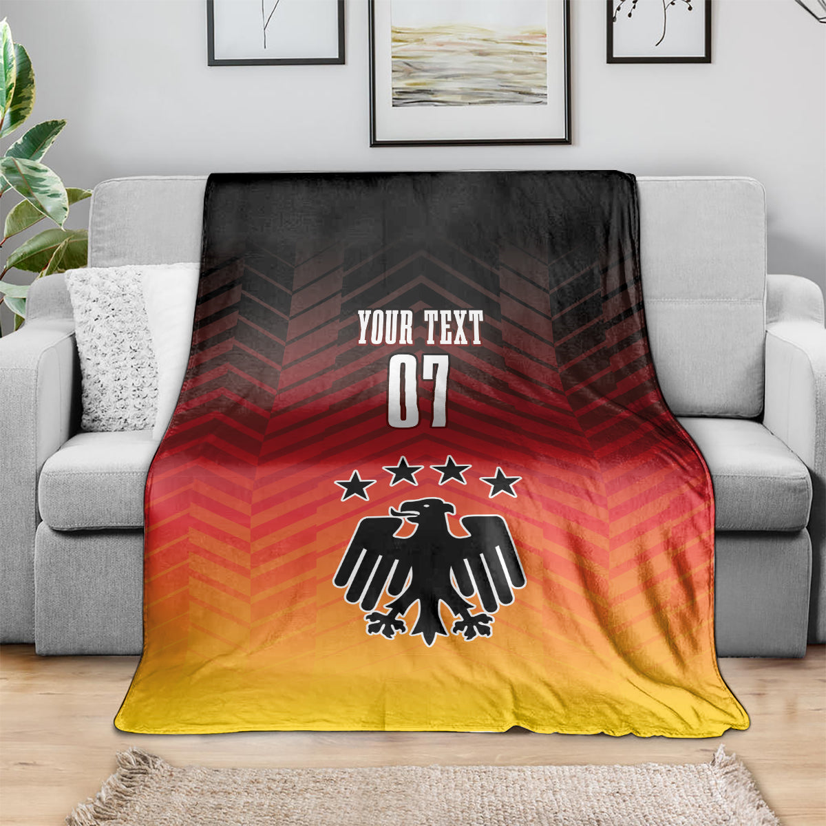 Football blanket on sofa, red-to-yellow gradient with eagle emblem, stars, and 'YOUR TEXT 07'